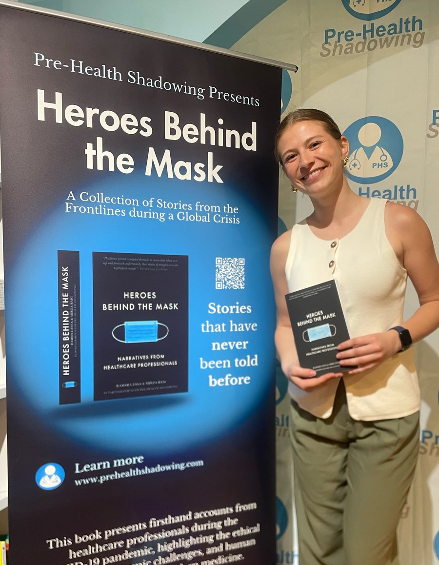 Trinity Maze at a Pre-Health Shadowing event, holding the book Heroes Behind the Mask